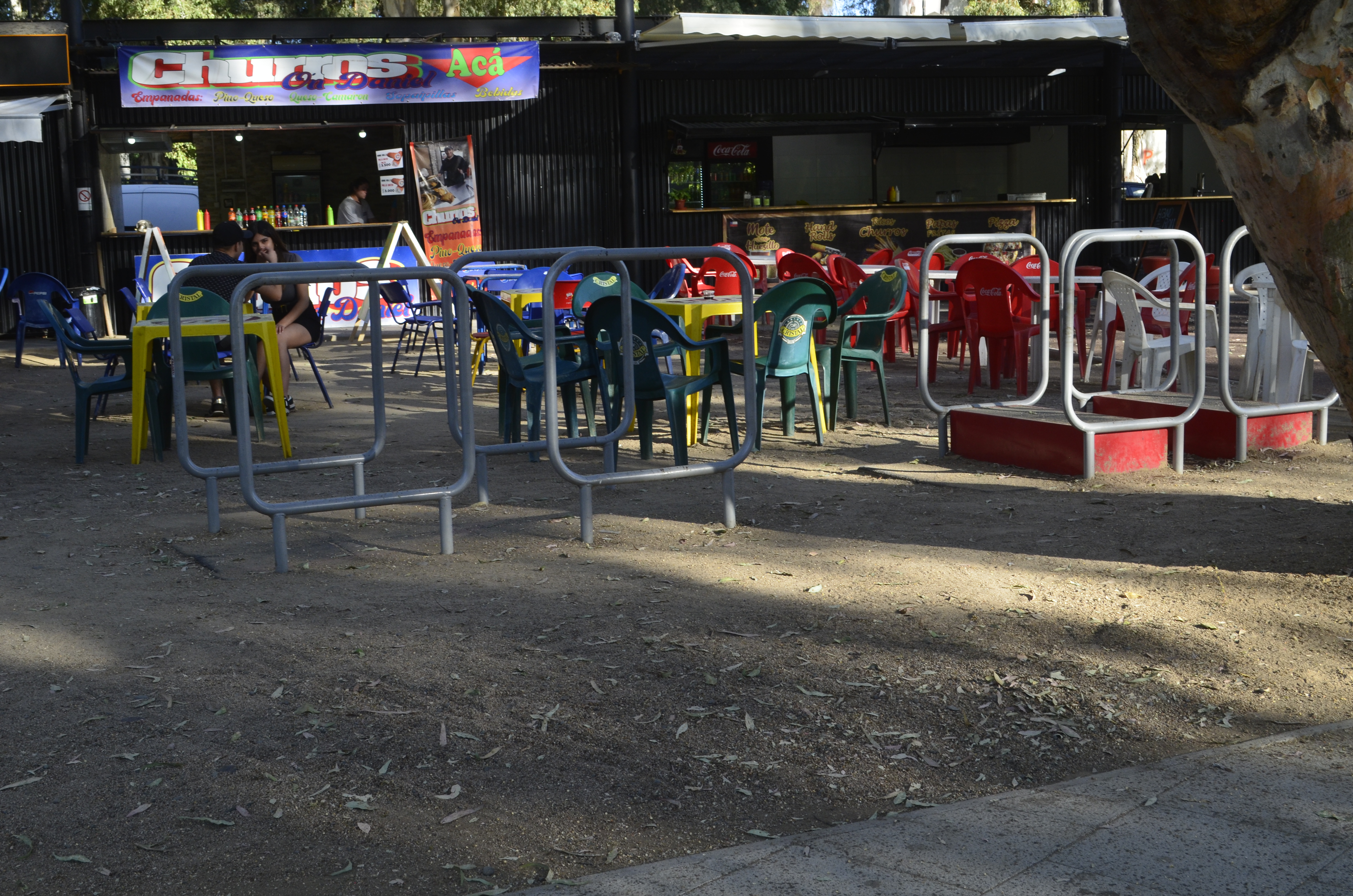 Fotografía de los foodtrucks desde otro enfoque, se destaca la cercanía de mesas y asientos